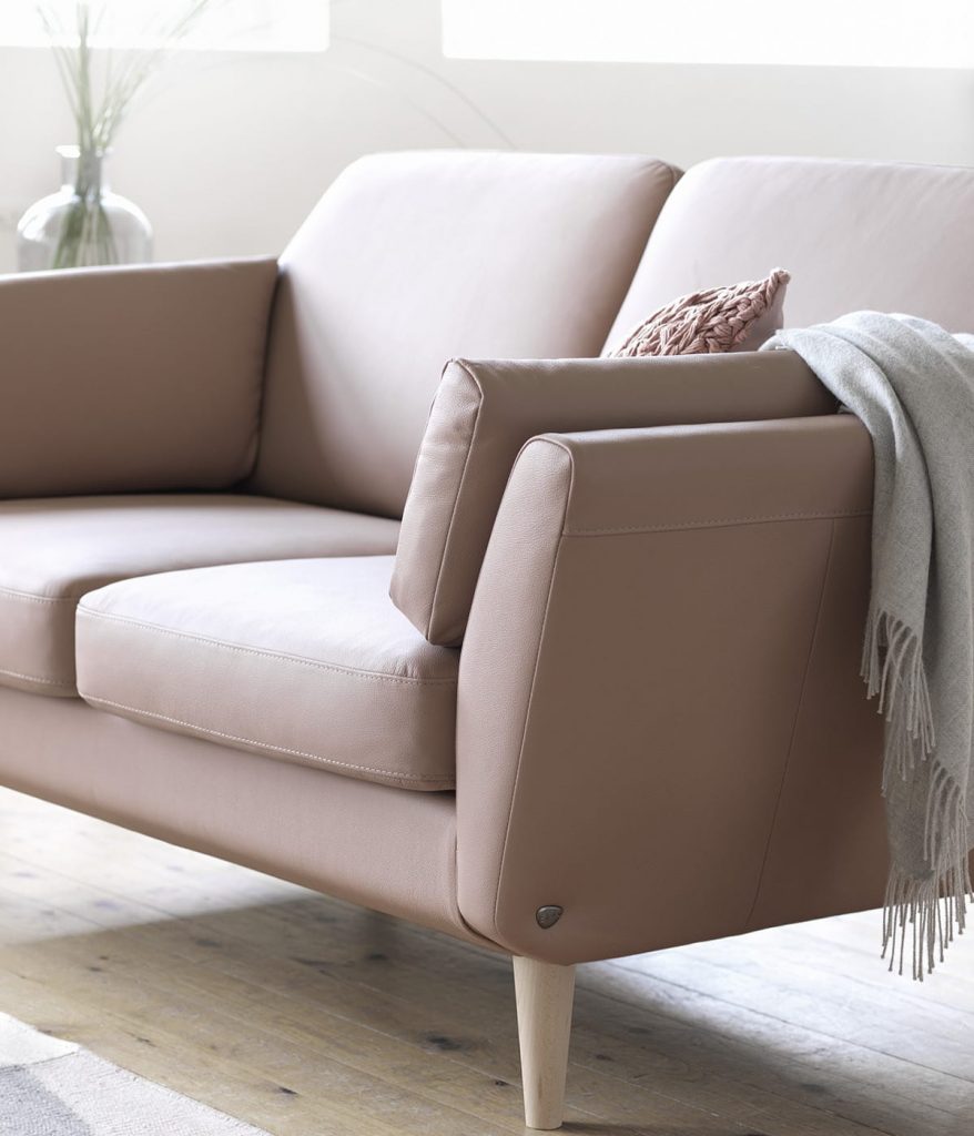 Der Lederfarbton Dusty Rose gehört zu den Farbtrends 2018 – wie hier bei dem Stressless Air Sofa mit Sofabeinen in einem hellen Holzton. 